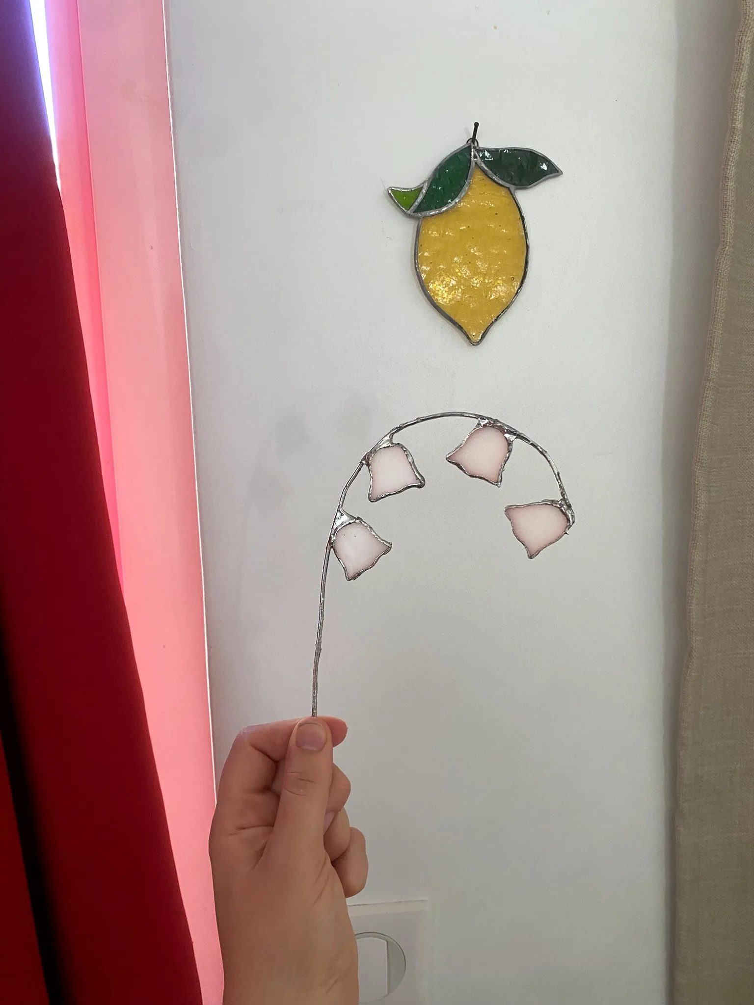 Le citron et le muguet en vitrail suspendus devant une fenêtre