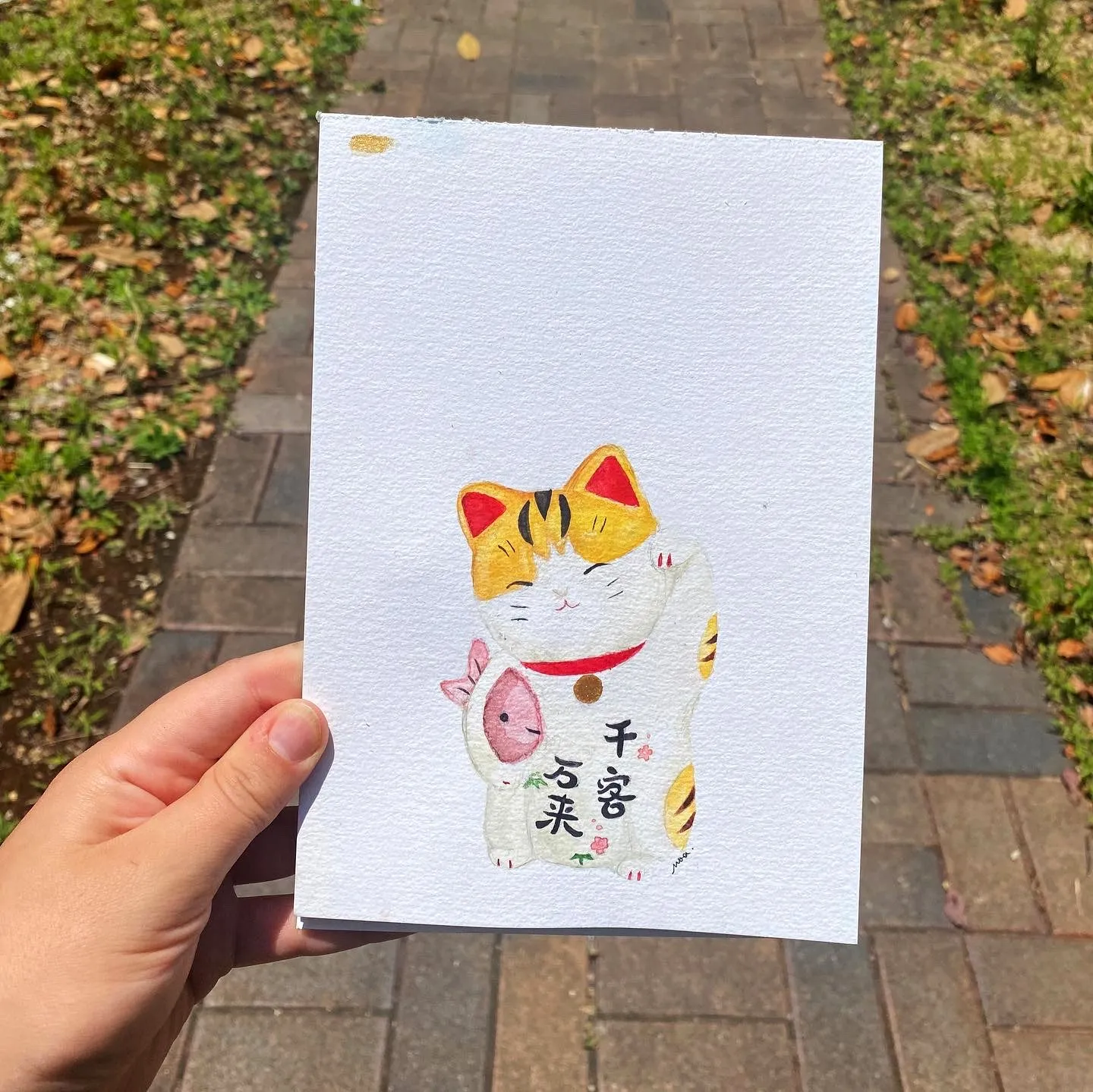 L'aquarelle du maneki-neko tenue en main