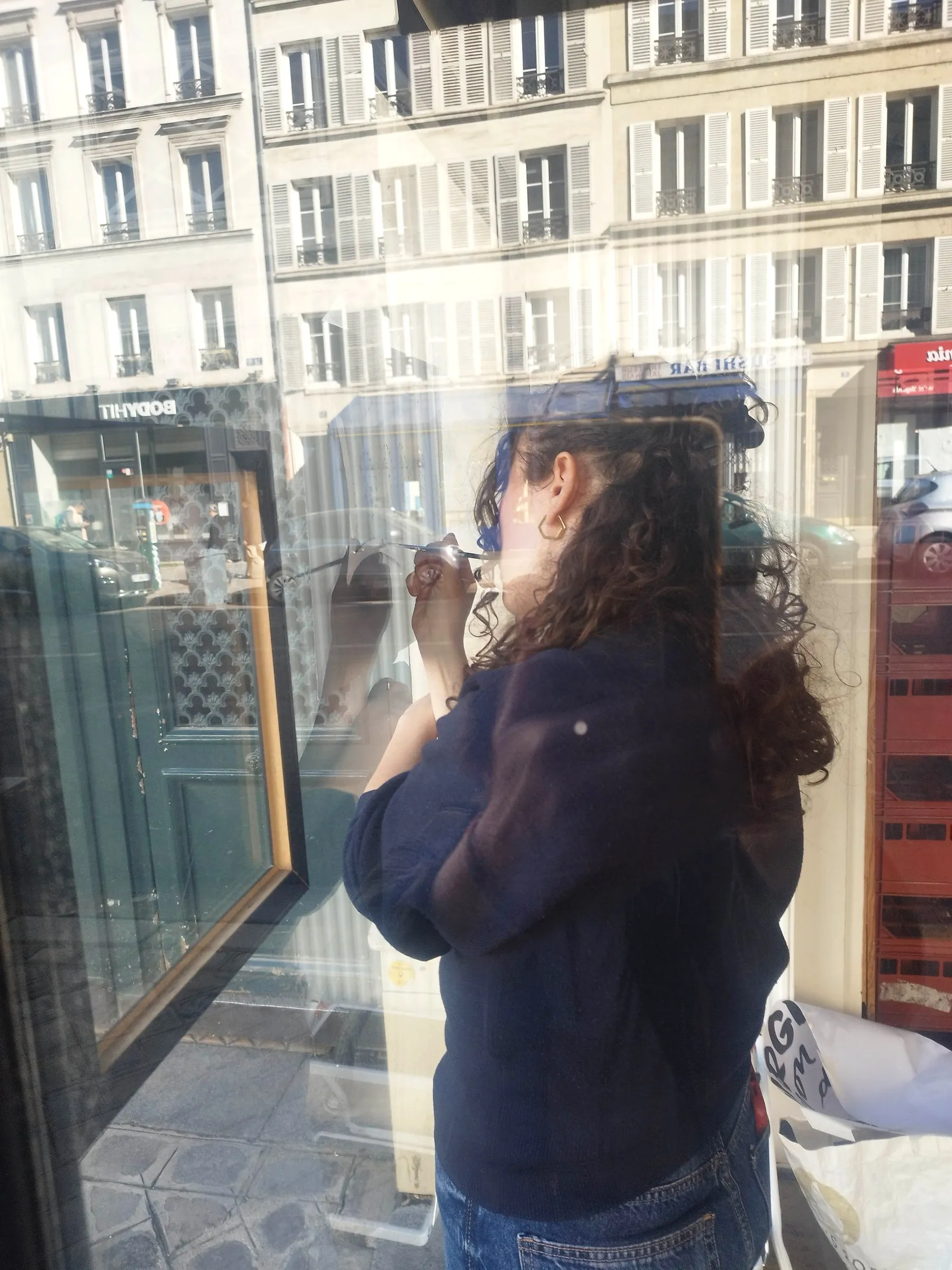 Peinture au pinceau traceur sur la vitre, le bras en appui
